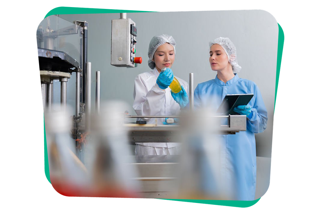 Two workers in protective clothing inspect a product in a laboratory or production setting. One holds a yellow bottle, and the other has a tablet.